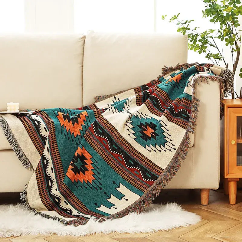 A cream bohemian throw blanket with teal orange black geometric patterns and fringed edges for bedroom decorbites bohemian decor