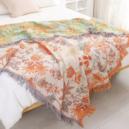 Decorbites bohemian sofa blanket featuring a cozy two-toned floral design with orange blossoms and green leaves