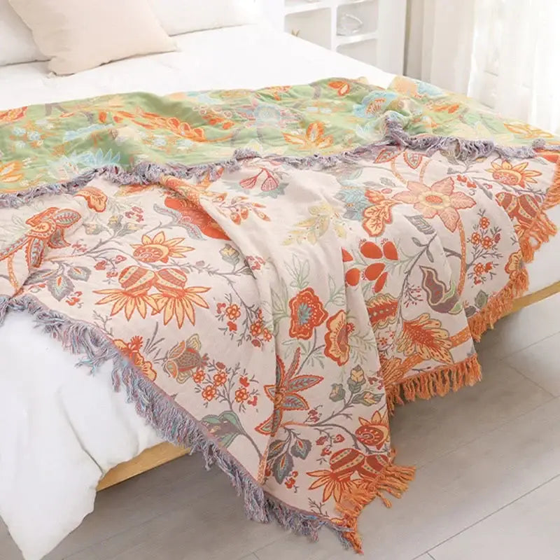 Decorbites bohemian sofa blanket featuring a cozy two-toned floral design with orange blossoms and green leaves
