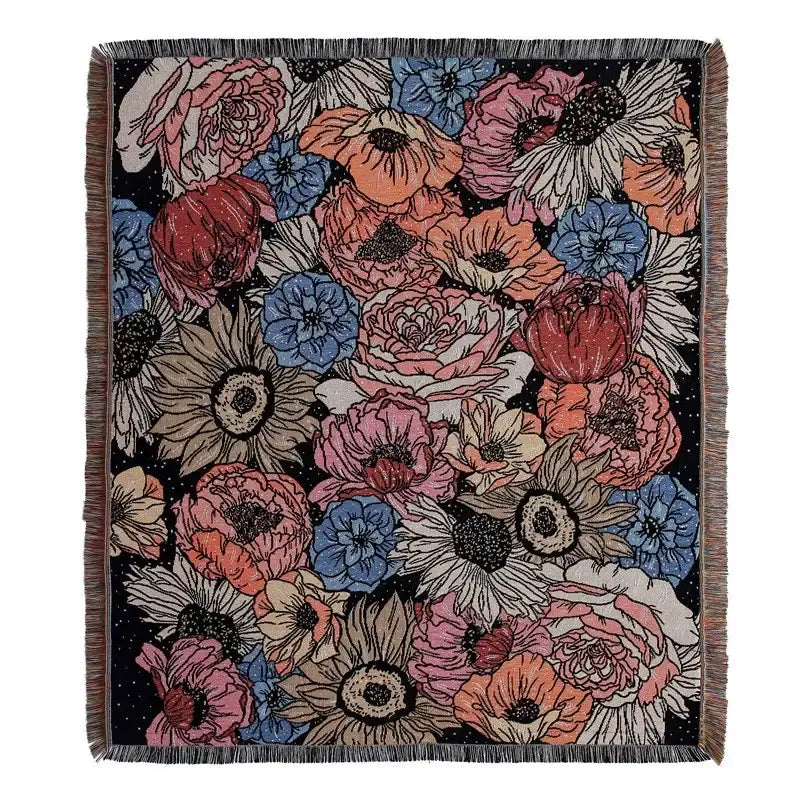 A decorbites bohemian outdoor blanket with vibrant floral pattern and textured fringe on black gray tiger tapestry rug