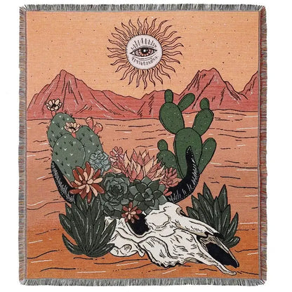 A decorbites bohemian outdoor blanket featuring a woven desert scene tapestry with cacti and eye-in-the-sun motif on orange