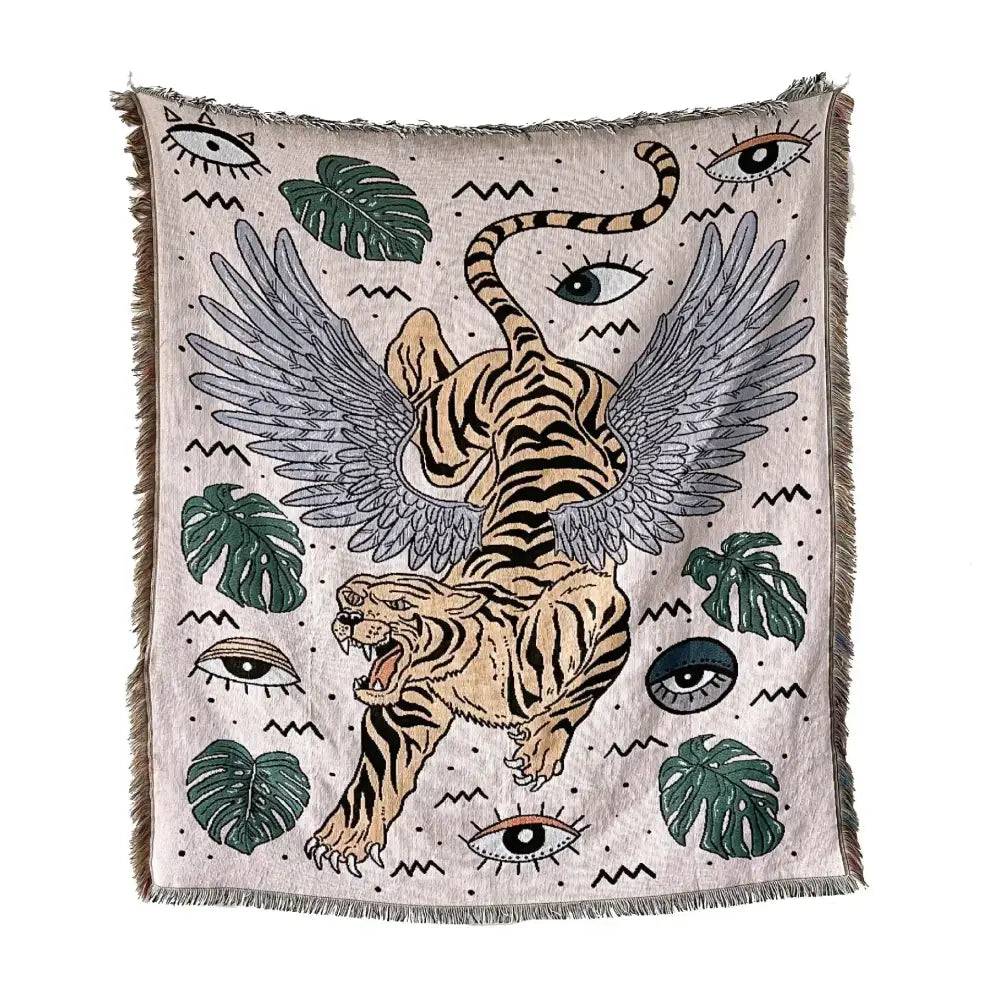 Beige woven decorbites bohemian outdoor blanket with winged tiger graphic and green monstera leaves on textured background