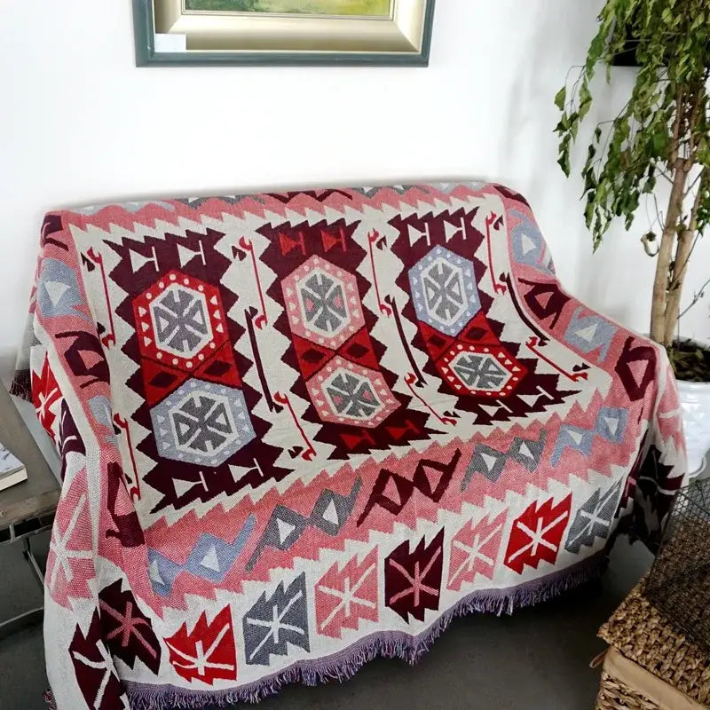 Bohemian pink and red knitted cotton throw blanket with geometric patterns and fringed edge for bedroom decorbites decor