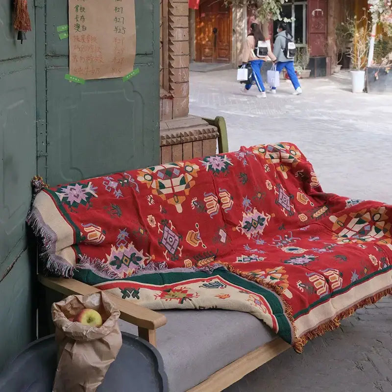 A vibrant red decorbites bohemian cotton thread knitted throw blanket with geometric floral patterns and fringed edges