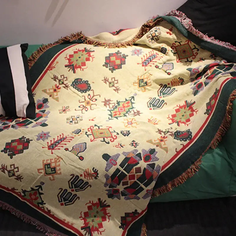 A cream-colored bohemian cotton thread knitted throw blanket with geometric patterns and fringed edges for living room decorbites