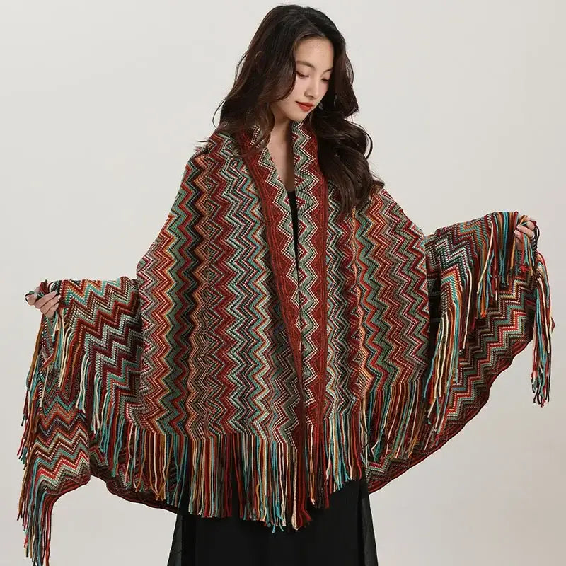 A vibrant knitted bohemian red and teal zigzag wavy fringe shawl with long fringe edges for living room use