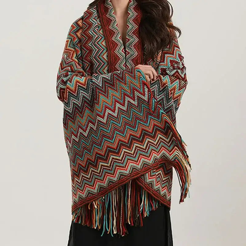 A vibrant knitted bohemian wavy fringe shawl with red teal and beige zigzag pattern and fringed edges