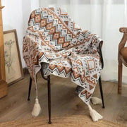 Cozy bohemian striped knit throw blanket in beige brown with geometric pattern and tassels for living room decorbites decor