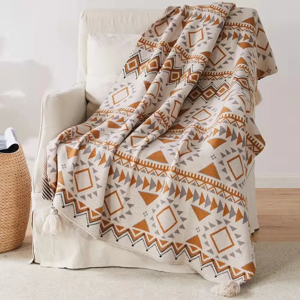 Cozy cream bohemian tassel knit blanket with geometric orange and gray pattern and corner tassels for decorbites decor