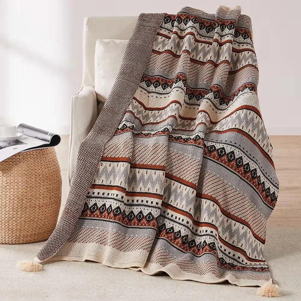 Cozy bohemian tassel knit blanket with geometric pattern in beige rust and gray featuring decorative tassels decorbites