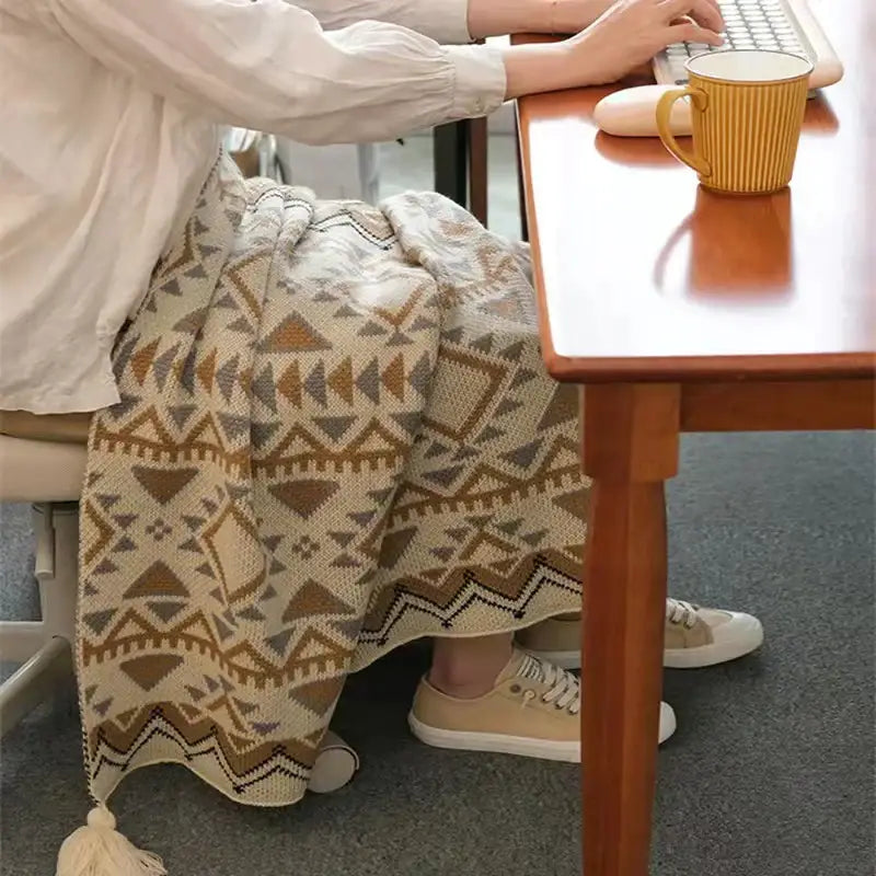 A cozy cream-colored bohemian tassel knit blanket with beige and brown geometric patterns for living room decorbites