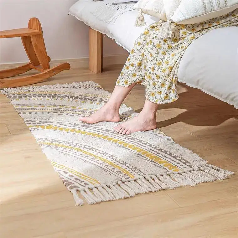 A cozy decorbites bohemian tassel rug in cream with mustard yellow and gray geometric patterns and fringed edges