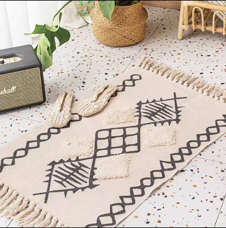 Beige woven bohemian tassel rug with black geometric patterns and cream tassels for living room decor by decorbites bohemian