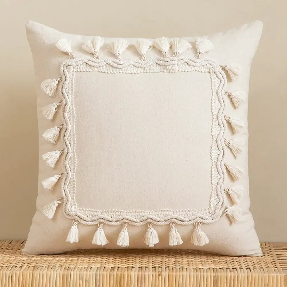 Cream-colored bohemian tufted tassel pillow with textured embroidered border and white tassels for living room decorbites