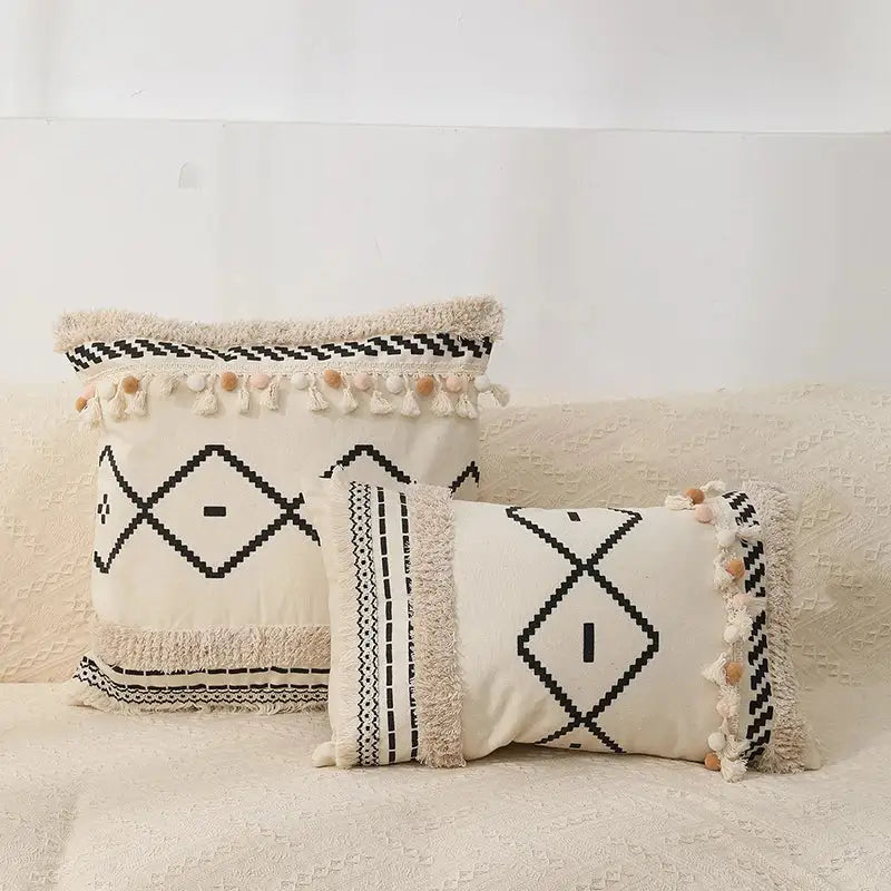 Cream-colored bohemian tufted tassel pillow with black geometric patterns and fringed edges for living room decorbites decor