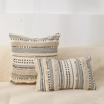 Cream-colored bohemian tufted tassel pillow case with black geometric patterns and fringed edges for living room decorbites