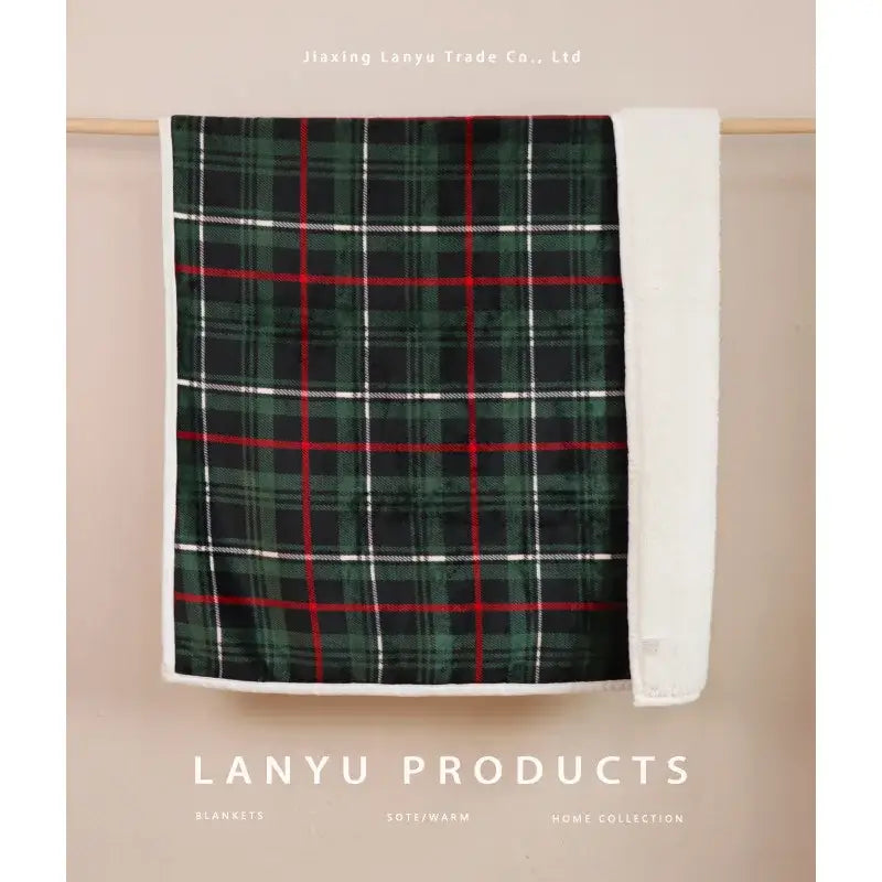 A cozy bohemian winter blanket in green red and white plaid with soft fleece lining for living room use