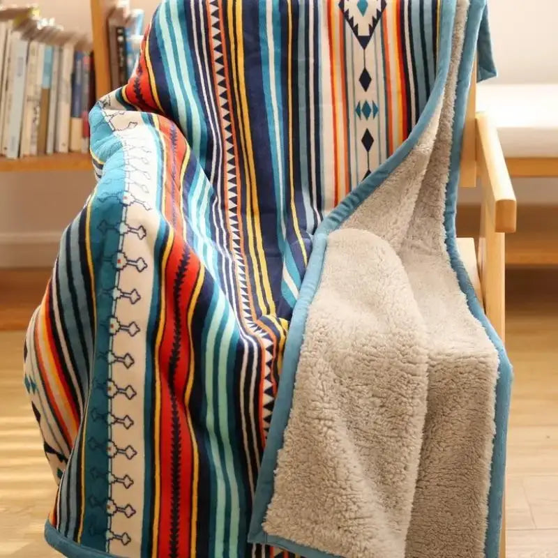 A cozy bohemian winter blanket fleece lined with vibrant blue red yellow and white stripes accented by turquoise trim