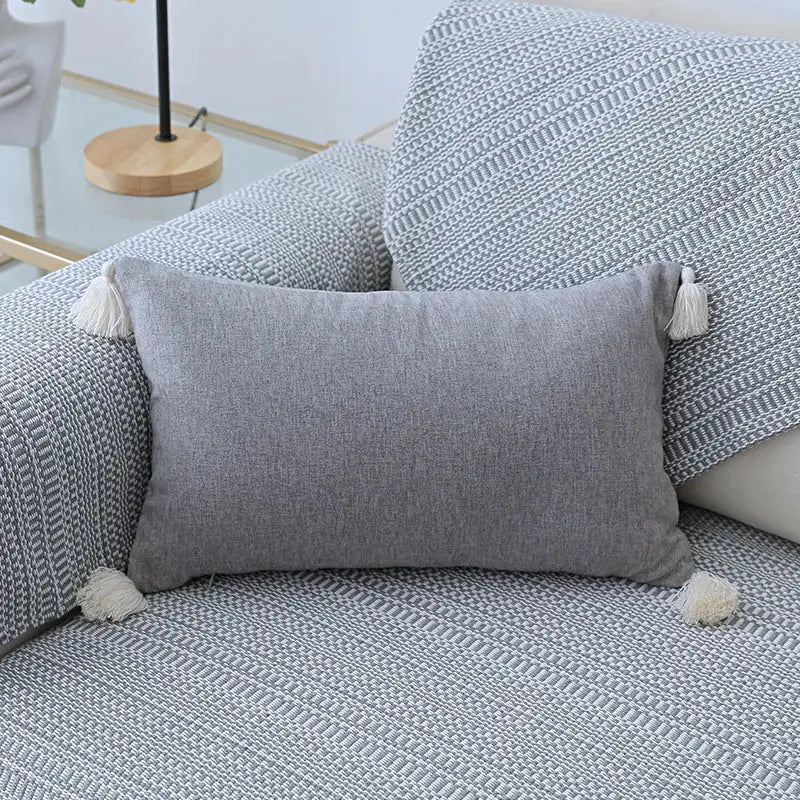 Boho beige linen tassel pillow cover set featuring a gray textured fabric pillow cover with white corner tassels