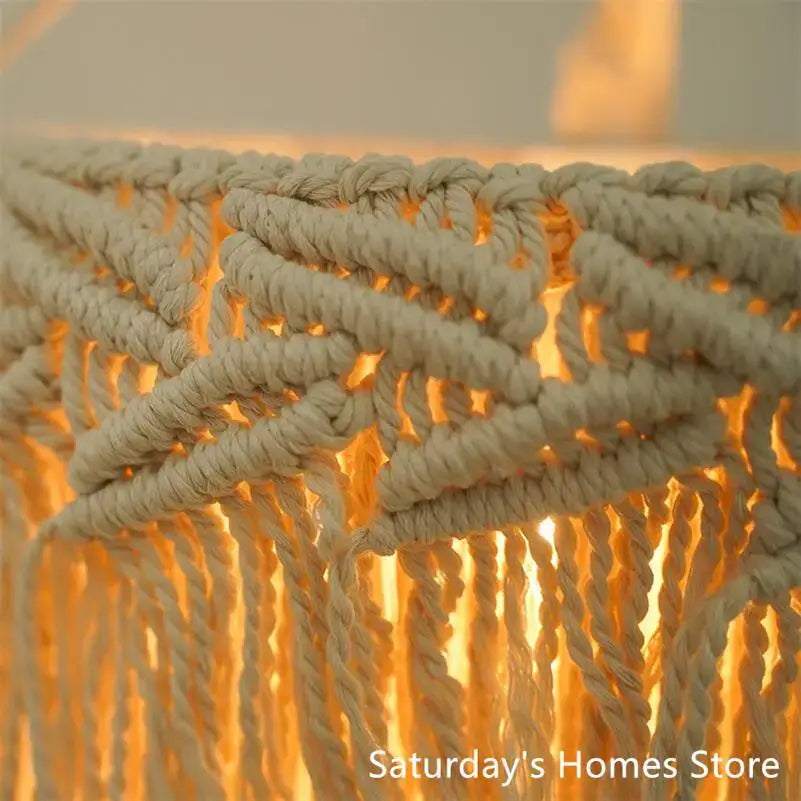 Cream-colored boho macrame pendant light cover with intricate woven rope patterns and fringe for bedroom chandelier
