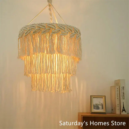 Cream-colored boho macrame pendant light cover with layered fringe and woven texture for bedroom chandelier