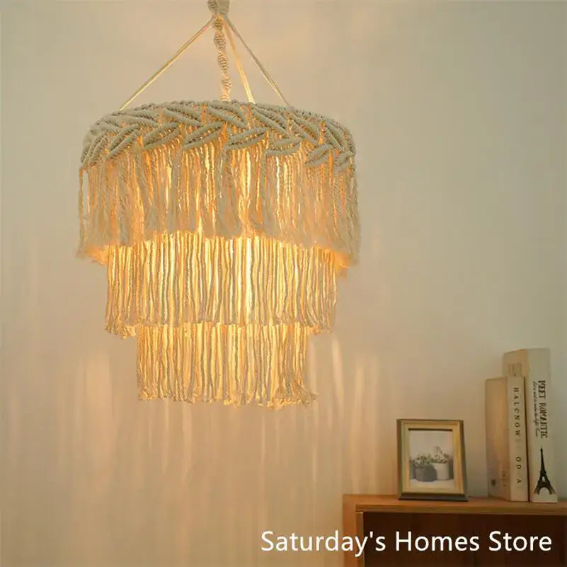 Cream-colored boho macrame pendant light cover with layered fringe and woven texture for bedroom chandelier