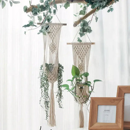 Beige boho macrame plant hanger basket with wooden dowels and tassels holding trailing green plants for living room decor