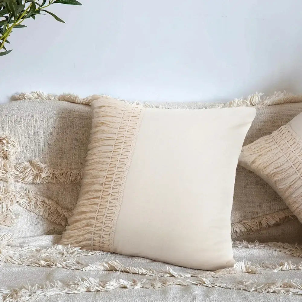 Cream-colored cushion cover with woven detailing and fringed border for decorbites beige boho style living room decor