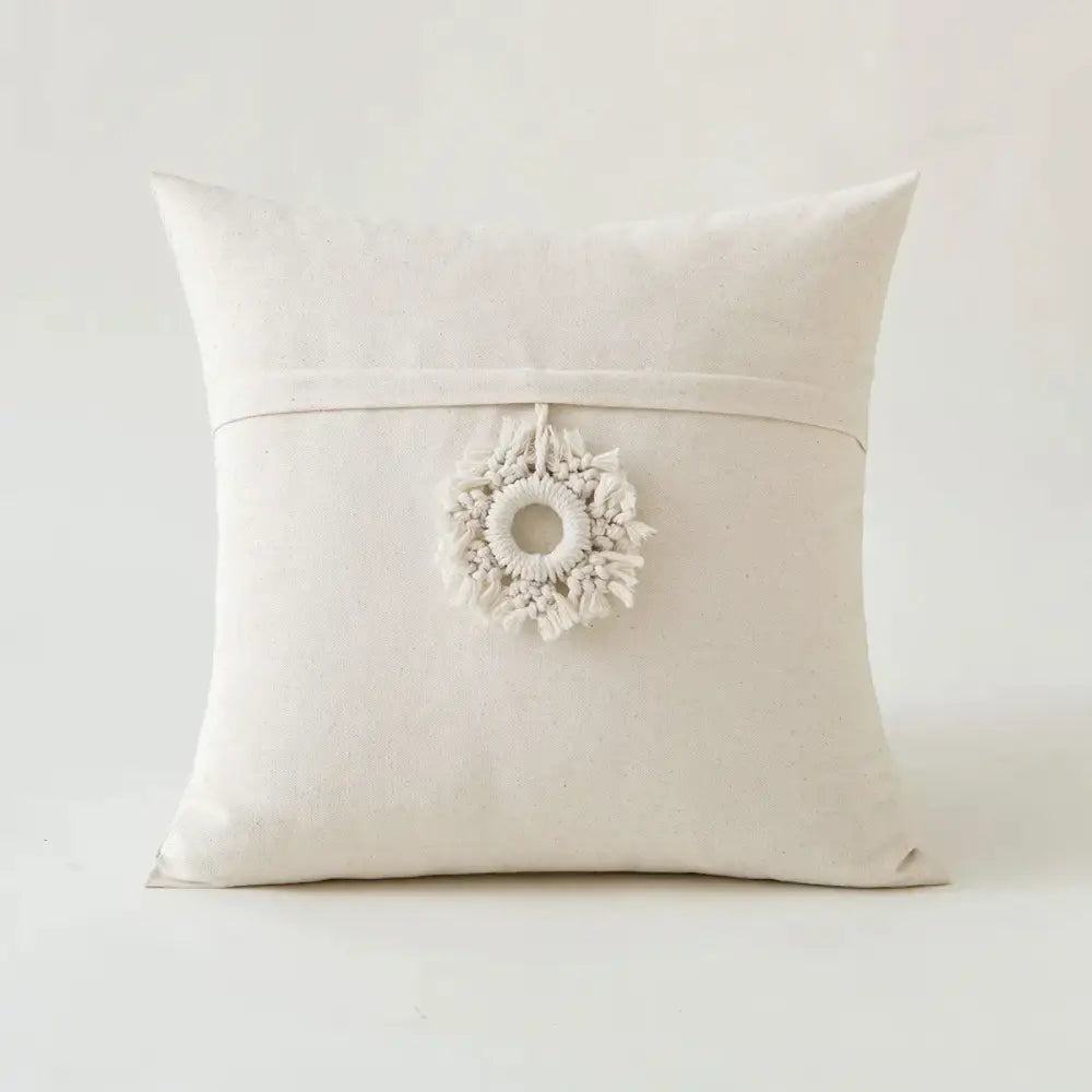 Off-white canvas cushion cover with delicate macrame wreath pendant in decorbites beige tufted fringed style