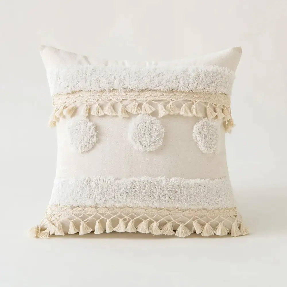 Cream-colored tufted fringed cushion cover with textured fabric tassels and fluffy pom-poms for living room decorbites beige tufted decor