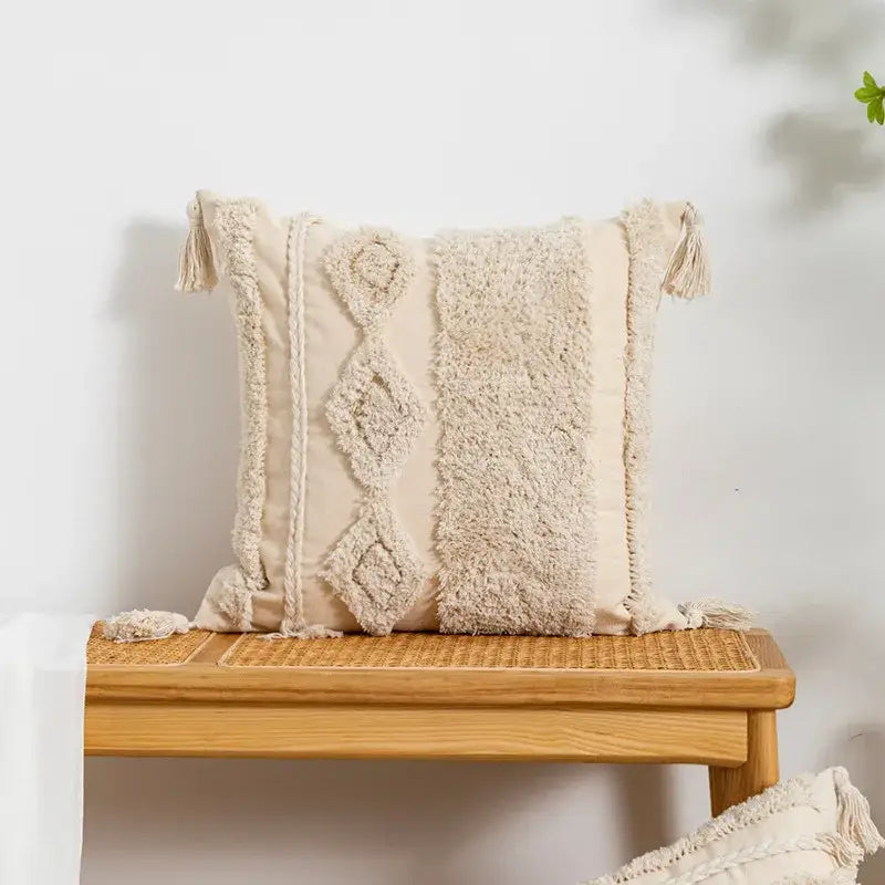 Cream-colored tufted fringed geometric pillow cover with textured woven patterns and tassels for living room decor
