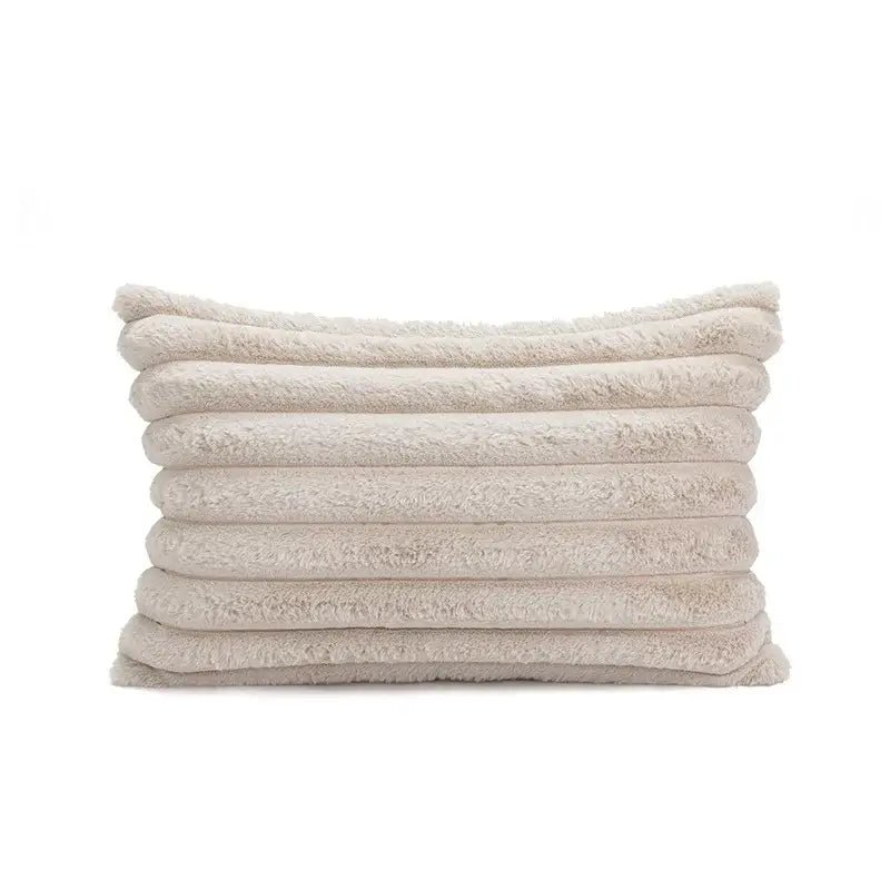 A plush off-white towel with a soft texture shown alongside a boho beige tufted fringed geometric pillow cover