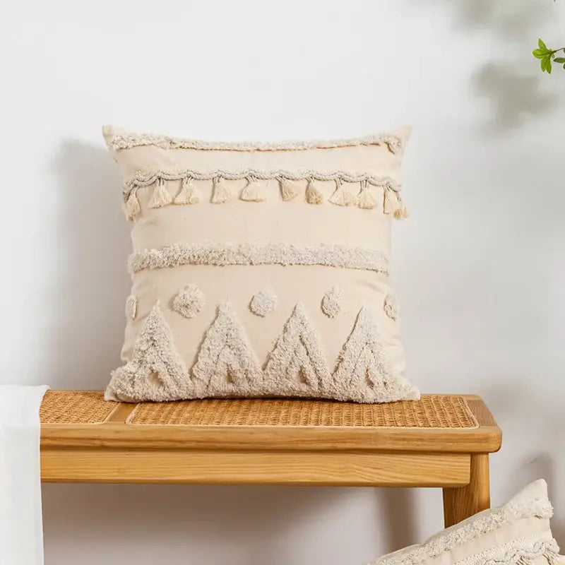 Cream-colored pillow cover with tufted fringed geometric texture and embroidered tree motifs for living room decor