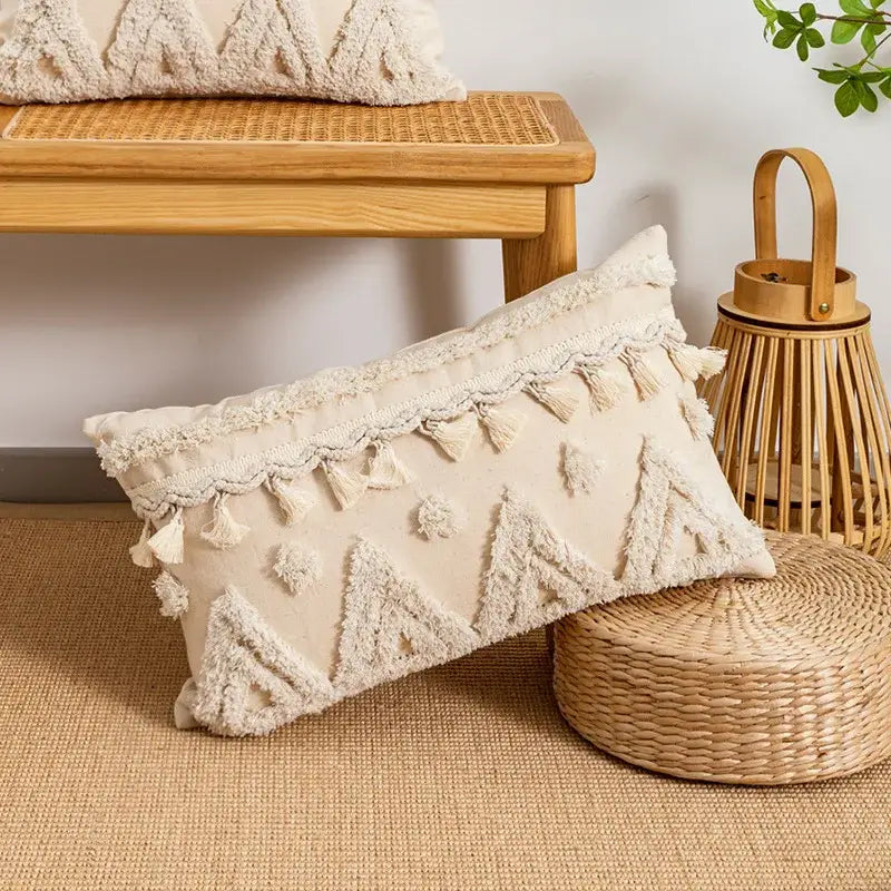 Cream-colored rectangular pillow cover with tufted fringed geometric texture and tassel trim for living room decor