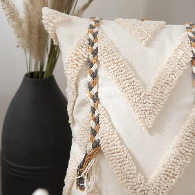 Cream-colored boho beige tufted pillow cover with textured braided trim in cream gray and tan tones for living room decor