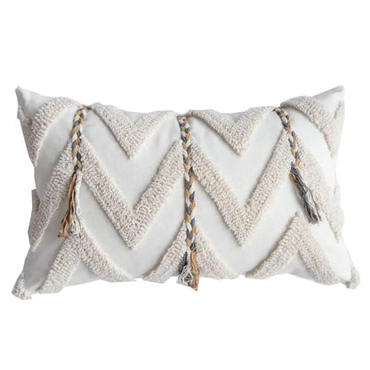 Cream-colored tufted pillow cover with textured chevron pattern and braided tassels in beige gray and tan for living room