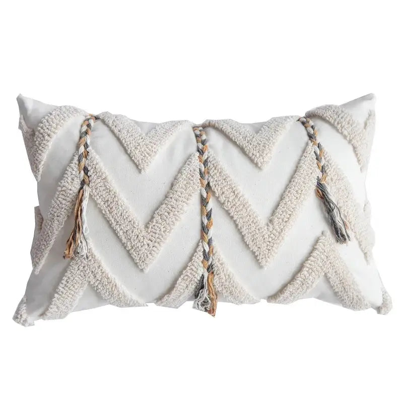 Cream-colored tufted pillow cover with textured chevron pattern and braided tassels in beige gray and tan for living room