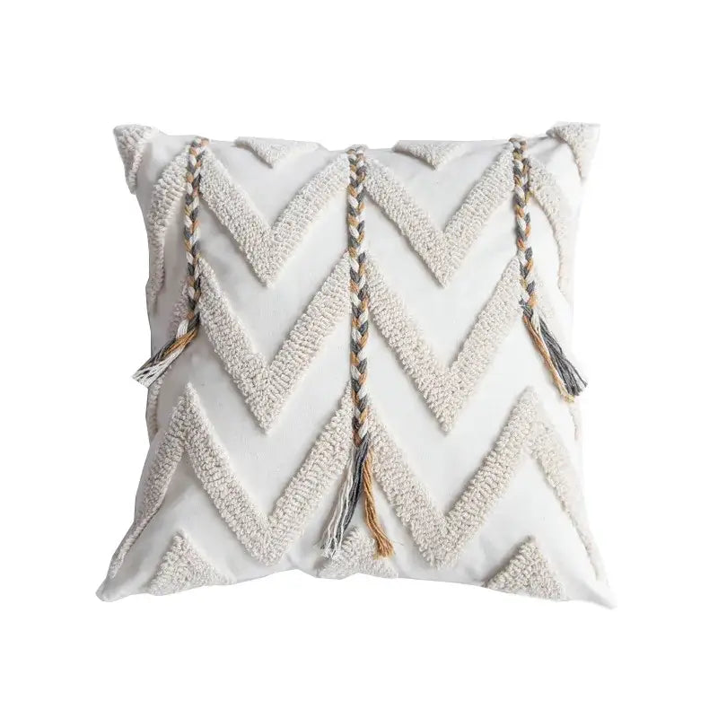 Cream-colored tufted pillow cover with textured zigzag pattern and braided tassels in beige gray and tan for living room