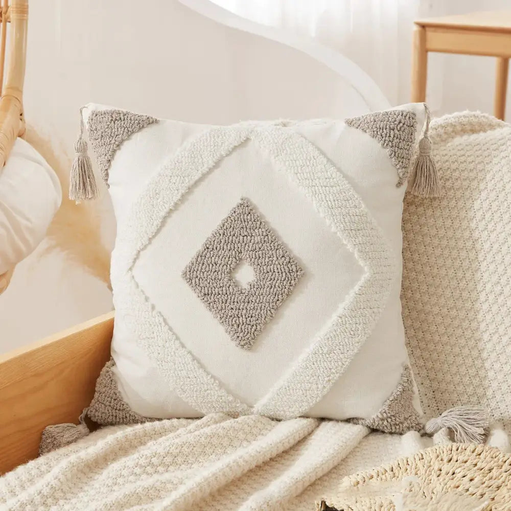 Cream-colored throw pillow case with textured gray diamond pattern and tassels for boho beige white decorbites decor