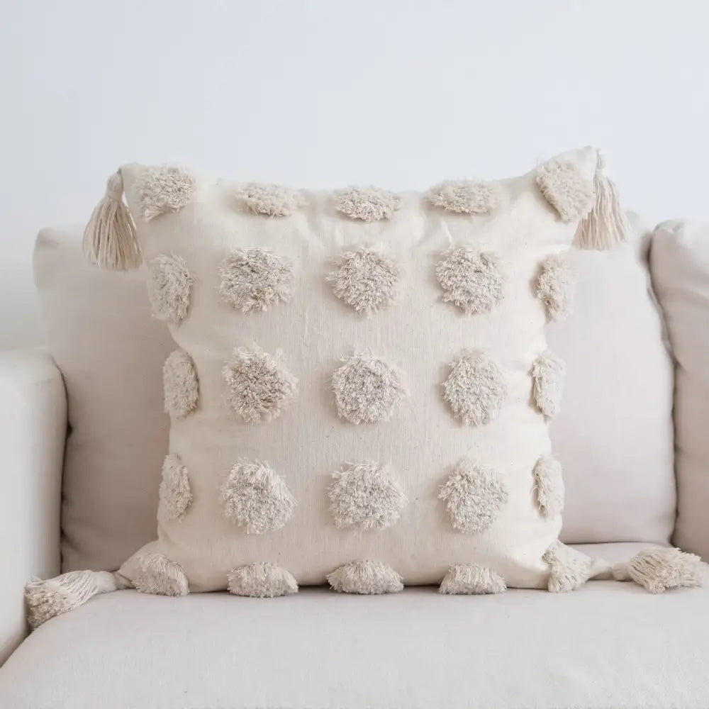 Cream-colored pillow case with textured woven fabric and fluffy pom-poms, perfect for decorbites boho beige white decor