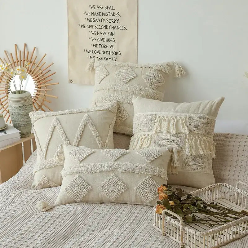Cream-colored textured throw pillows with geometric embroidery and tassels for boho beige white bedroom decorbites boho beige