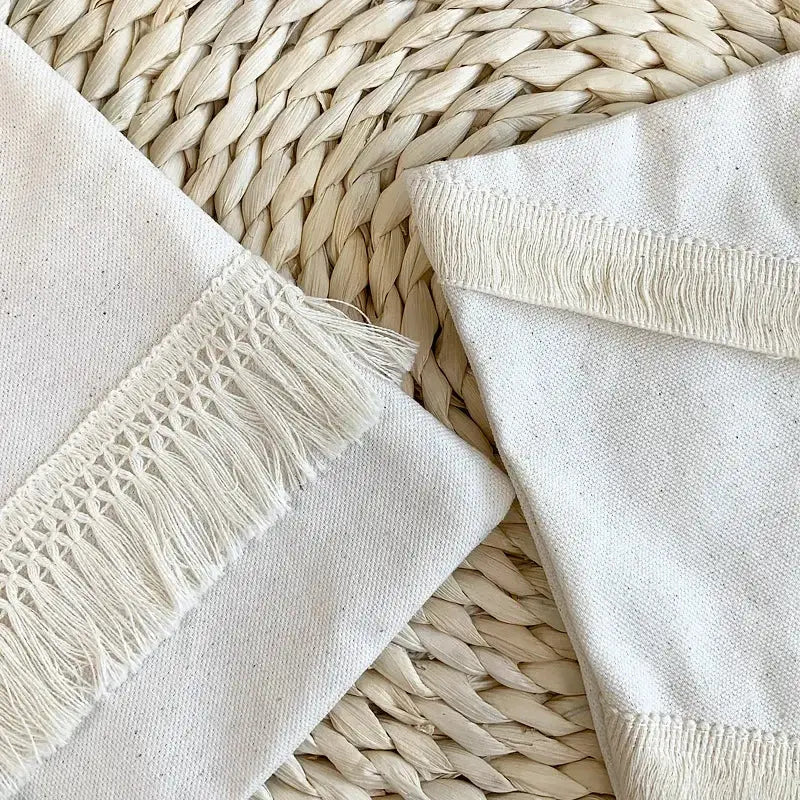 Off-white canvas napkins with frayed edges complementing boho beige and yellow linen cotton pillow covers for living room decor