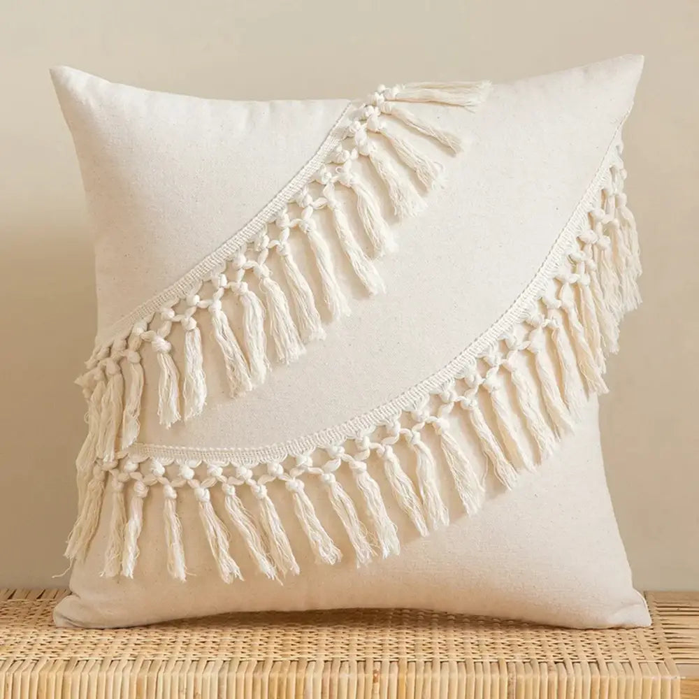 Cream-colored square pillow cover with two diagonal rows of macrame fringe made of linen cotton for living room decor