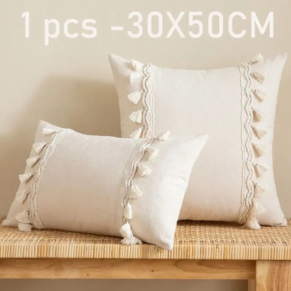 Cream-colored rectangular pillow cover with woven tassel trim made of linen cotton for boho living room decor