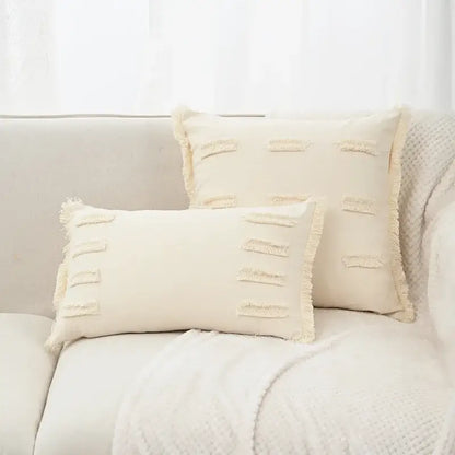 Cream-colored rectangular linen cotton pillow cover with frayed edges and horizontal tassel accents for living room decor