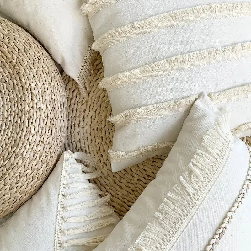 Cream-colored linen cotton pillow cover with fringed edges and woven detailing for boho living room decor