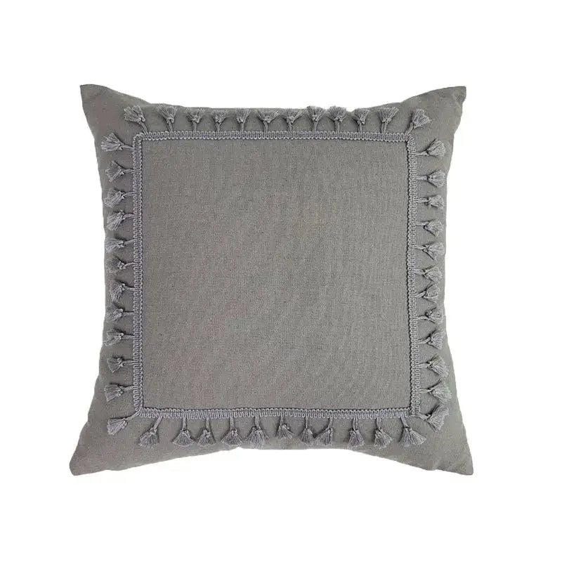 Gray square pillow cover with textured linen cotton fabric center and decorative tassels for living room decor