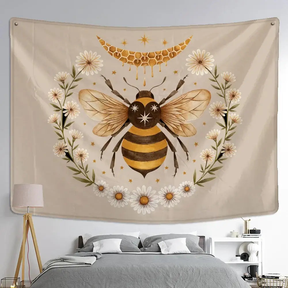 Beige wall hanging tapestry featuring a black and gold bee surrounded by white daisies in a boho daisy wall hanging design