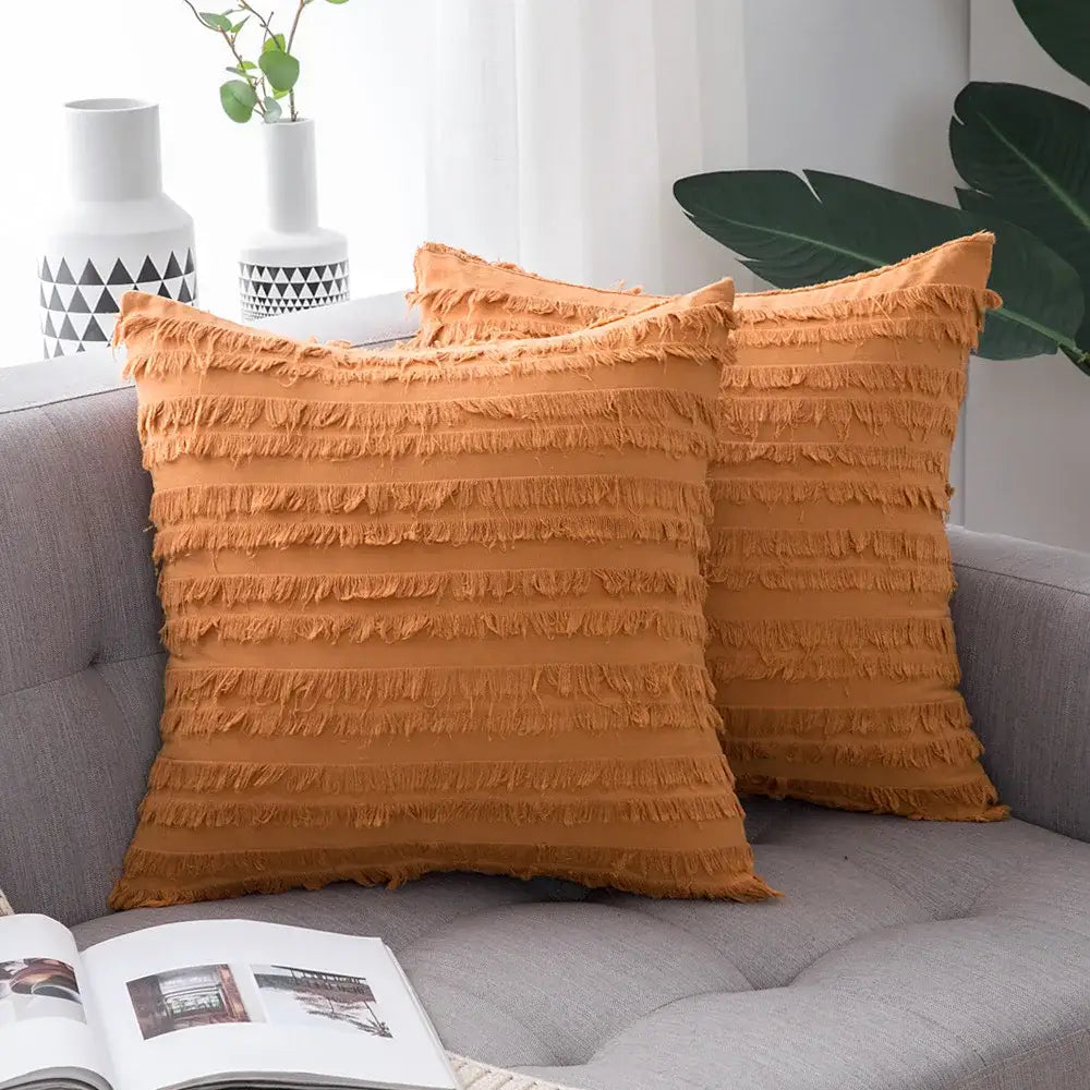 Warm orange throw pillow covers with layered fringe detailing and tassel striped design for boho home decor