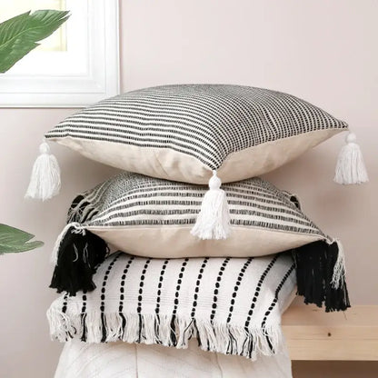 Stack of three black and white boho jacquard flower pillow cases with tassels for living room decor by decorbites